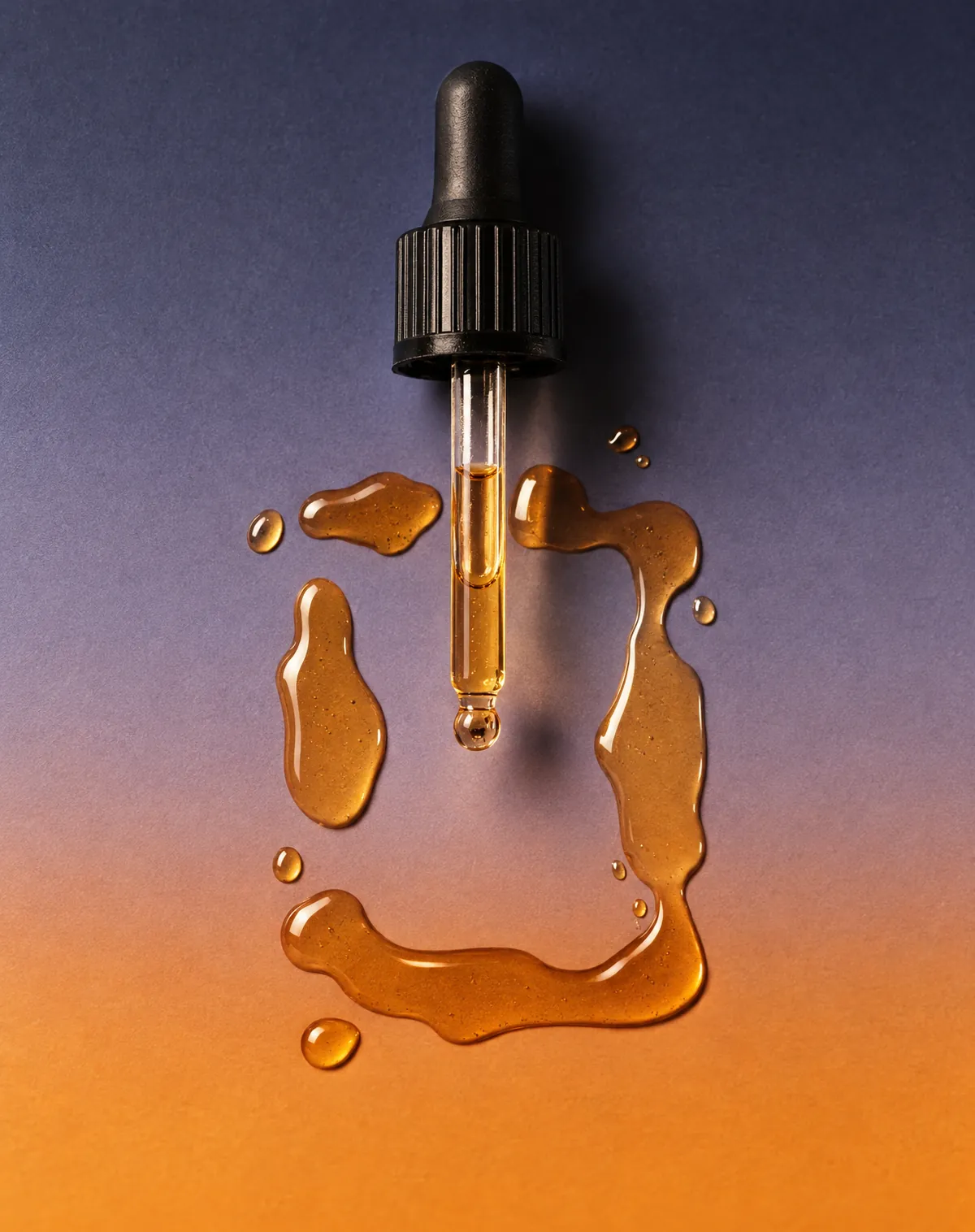 A dropper and a pool of tincture on a colour gradient